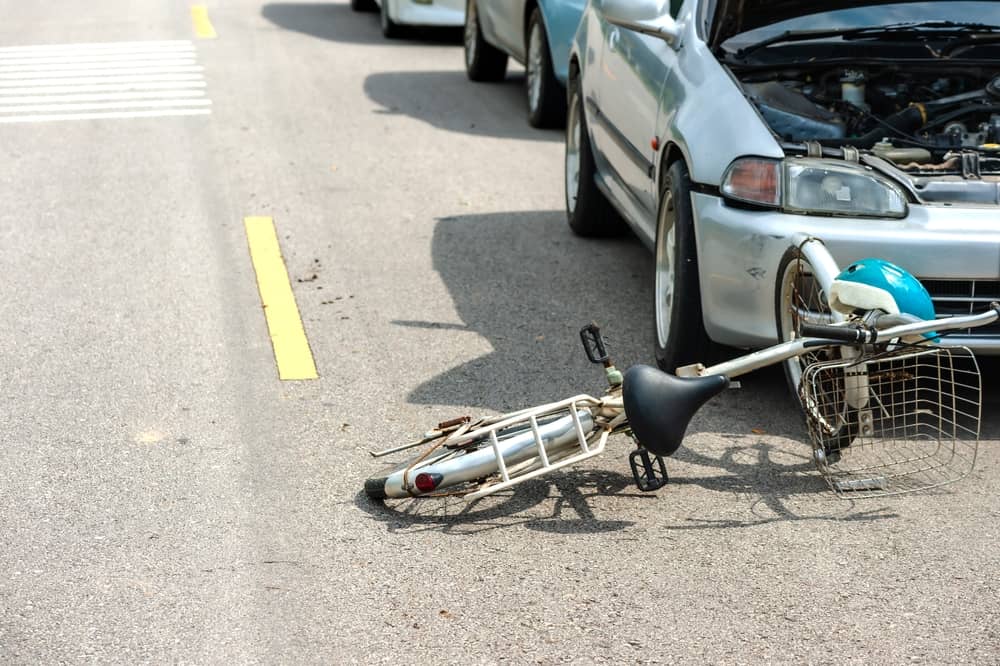 Bicycle lying on the road in front of a vehicle after a traffic collision
